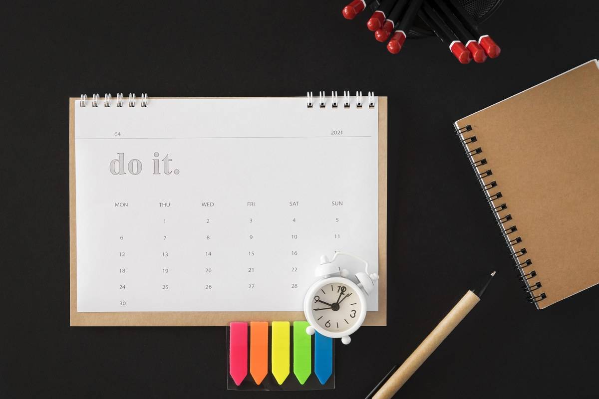 Calendrier et réveil sur un bureau : après la certification Qualiopi, l'audit de surveillance et le renouvellement ont leurs échéances
