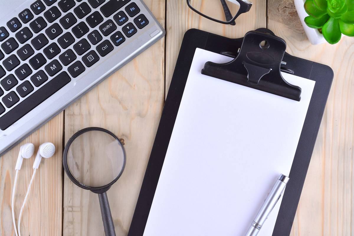 Porte-documents vierge et loupe sur un bureau, pour vérifier les preuves d'un audit Qualiopi
